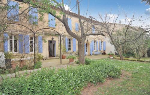 une grande maison en briques avec un arbre en face de celle-ci dans l'établissement Awesome Home In Arles, à Albaron