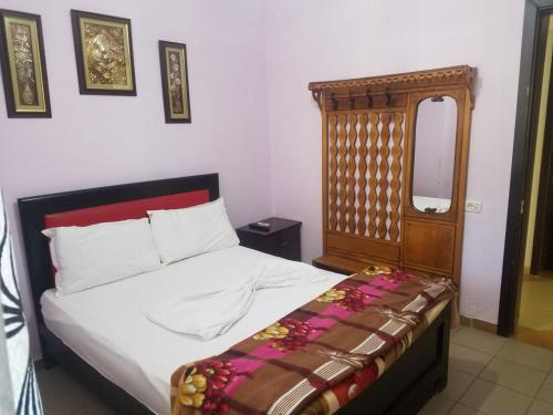Zhaban的住宿－Hotel Flora，一间卧室配有一张带木制床头板的床