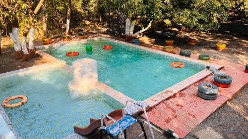 a swimming pool with a water fountain in a yard at Brook Ville in Sasan Gir