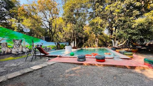 a swimming pool with a painting on the side of it at Brook Ville in Sasan Gir