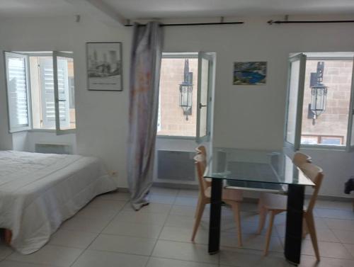 um quarto com uma cama, uma mesa e janelas em T1 Vieux Port Opéra em Marselha
