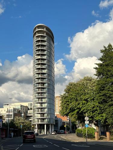 a tall glass building on the side of a street at A Stylish Flat Offering a Private Bedroom Near Landmark of Portsmouth in Portsmouth