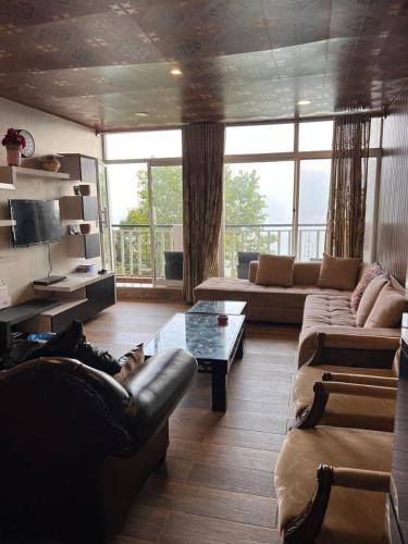 a living room with two couches and a table at Blue sky Apartment in Nathia Gali