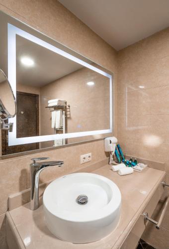 a bathroom with a sink and a large mirror at Dreamland Oasis Hotel Chakvi in Chakvi