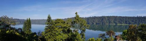 a view of a large lake with trees in the background at Umah Tyang Pancasari in Bedugul