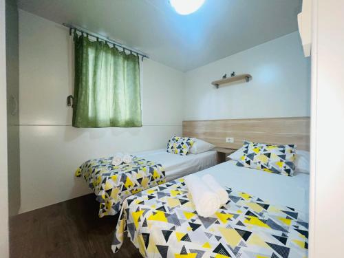 Habitación con 2 camas y ventana en Mobile home Comfort Jezera Murter en Jezera