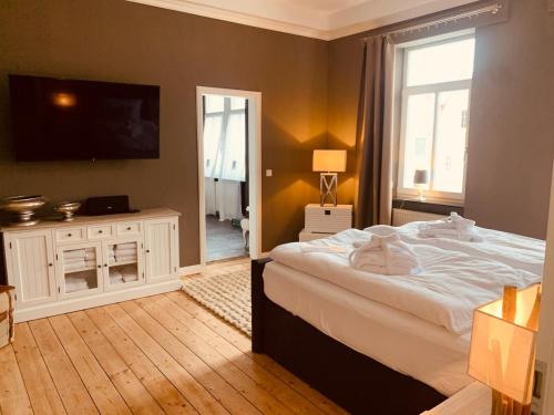 um quarto com uma cama grande e uma televisão em The Hampton Hock's - Wellness & Wine em Freinsheim