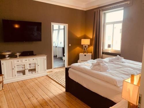 una camera da letto con un letto grande e una televisione di The Hampton Hock's - Wellness & Wine a Freinsheim