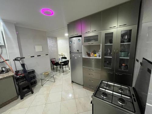 Il comprend une cuisine équipée d'un réfrigérateur et d'une table. dans l'établissement Annour Luxurious & Large apartment in Oujda Centre, à Oujda