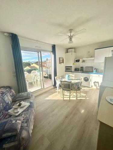 een woonkamer met een bank en een tafel en een keuken bij Studio en résidence WIFI VALRAS-PLAGE in Valras-Plage