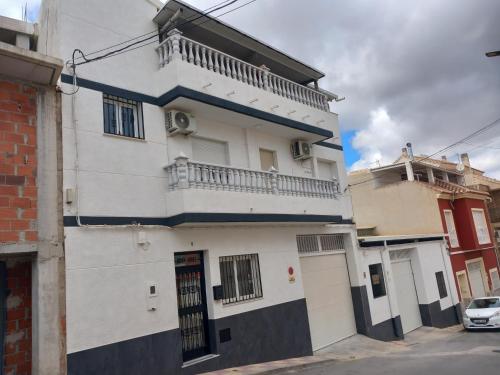 un edificio blanco con balcón en una calle en Apartamento Buena Vista, en Cehegín