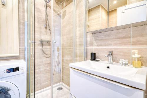 une salle de bain avec un lavabo et une machine à laver dans l'établissement Apartment 4 Pers. Moulin Rouge-Pigalle, à Paris
