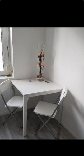 ein weißer Schreibtisch mit einer Vase darüber in der Unterkunft La casa del noche in Amiens