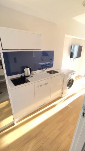 a white kitchen with a washing machine in it at Skyfall Rezidans in Kemerkoy
