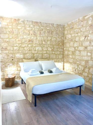 a bed in a room with a stone wall at Casa DaviRì in Modica