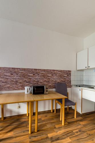 a kitchen with a table with a microwave on it at Apartmenthaus in Chemnitz für Monteure in Chemnitz