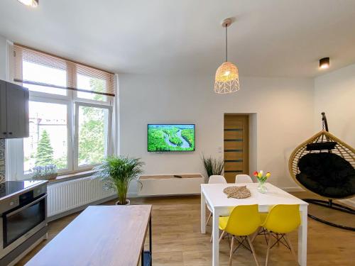 a living room with a white table and yellow chairs at 34_Boho - DeerRest Apart in Jelenia Góra