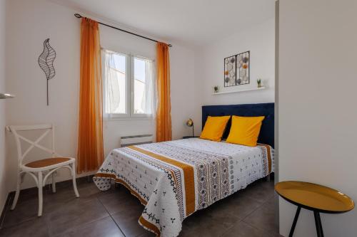 a bedroom with a bed with yellow pillows at Mimosas - Maison plain pied climatisée in Saint-Victor-la-Coste
