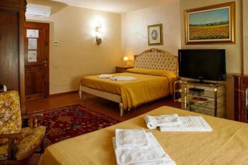 um quarto de hotel com duas camas e uma televisão de ecrã plano em Agriturismo Podere Bucine Basso em Lari