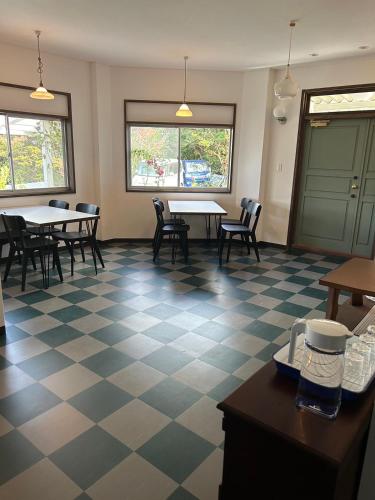 a dining room with tables and chairs and a checkered floor at Tainan House Awaji in Awaji