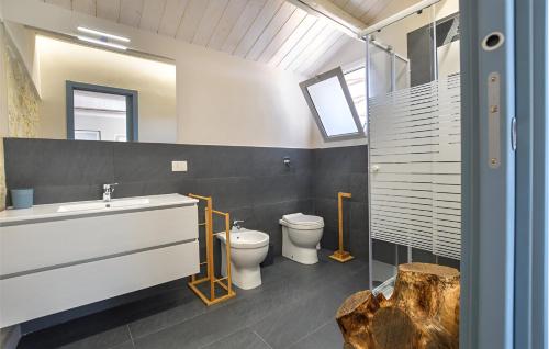 een badkamer met 2 toiletten, een wastafel en een spiegel bij Casa DaviRì in Modica