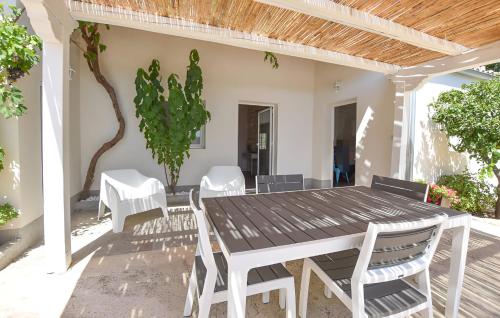 een houten tafel en stoelen op een patio bij Casa DaviRì in Modica