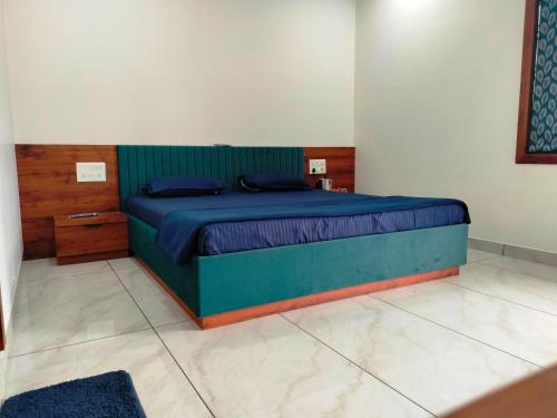 a bedroom with a bed with a blue bedspread at Unique Couple Friendly Stay in Morbi