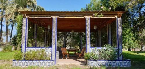 a gazebo with a table and chairs in a park at Pink Lemon House in Elche