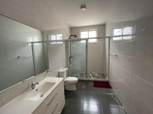 a bathroom with a toilet and a sink and a mirror at RESIDENCIAL EUNICE in Praia