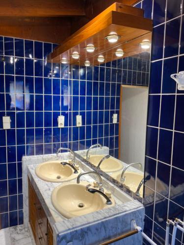 a bathroom with three sinks and a blue tiled wall at Pink Lemon House in Elche