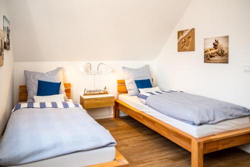 two beds in a room with blue and white at Tweete Heimaat in Büsum