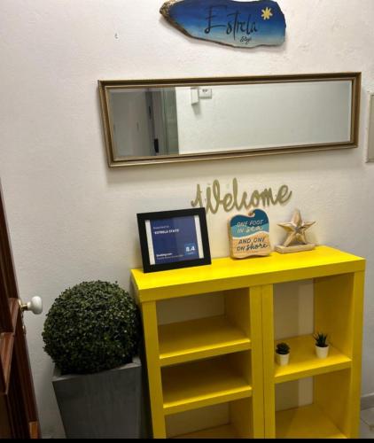 a yellow table with a laptop on it under a mirror at 'ESTRELA STAYS' in Lagos