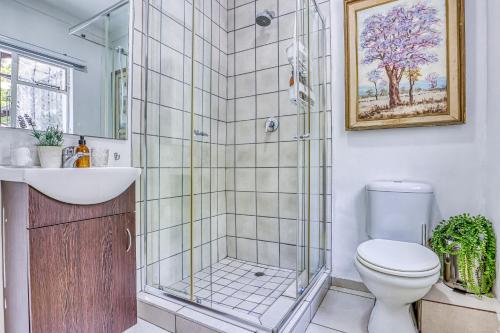 a bathroom with a shower and a toilet and a sink at Chic Midtown Studio-1 Bed-solar-pool-fibre-samrand in Centurion
