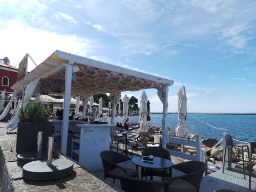 a restaurant with tables and chairs and the water at Apartment Crikvenica, Vinodol 2 in Crikvenica
