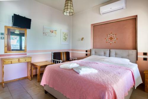 a bedroom with a large bed with a pink blanket at Garden Guest Room in Fanárion