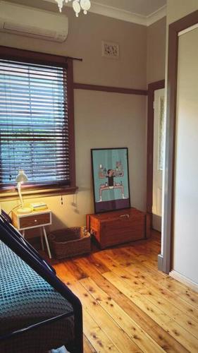 a living room with a television and a wooden floor at Private and spacious home away from home in Dubbo in Dubbo