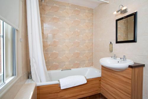 a bathroom with a sink and a bath tub at The Shrewsbury Hotel Wetherspoon in Shrewsbury
