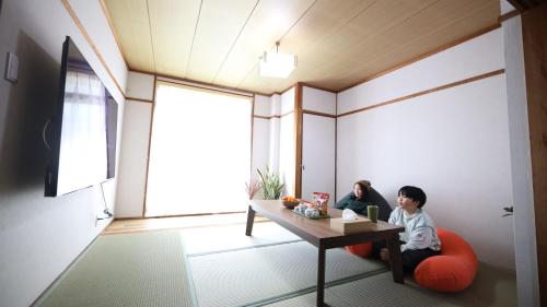 two children sitting at a table in a room at Tainan House台南家 in Awaji