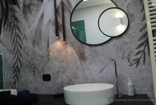 a bathroom with a white sink and a mirror at Villa CliCla - Pool, sea,hommock swing and laziness in Imperia