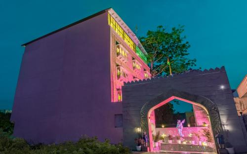 un edificio con luces rosas en el lateral. en Treebo Trend Haveli Resort Roots, Bhupatwala Haridwar, en Haridwar