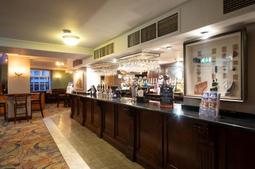 eine Bar in einem Restaurant mit Tischen und Stühlen in der Unterkunft The Shrewsbury Hotel Wetherspoon in Shrewsbury