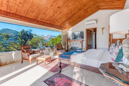 a bedroom with a bed and a large window at SaffronStays Naiintara in Nainital