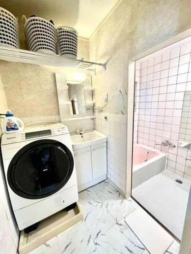 a kitchen with a microwave and a bath tub at 舞浜の一軒家 3寝室 6ベッド 東京ディズニーリゾートまで車5分 東京駅から好アクセス in Urayasu