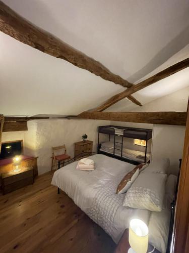 une chambre avec un grand lit dans une pièce avec parquet dans l'établissement Barn Long House with Private pool, à Chassenon