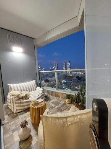a living room with a view of a city skyline at Gindi Tower Apartments TLV in Tel Aviv