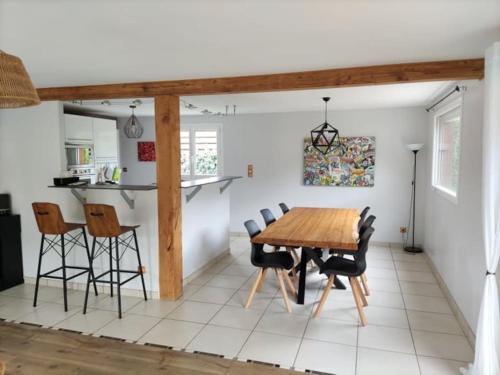 uma sala de jantar com uma mesa de madeira e cadeiras em Maison avec jardin au pied du Viaduc de Millau em Creissels