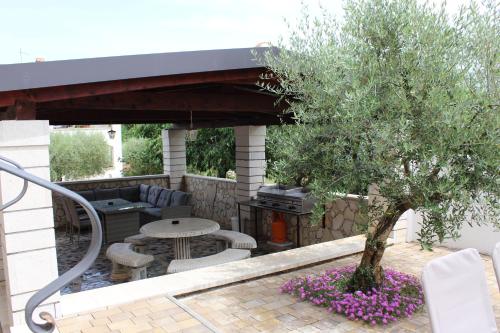 a patio with a tree and a table and a grill at Apartmens Kimm II in Poreč