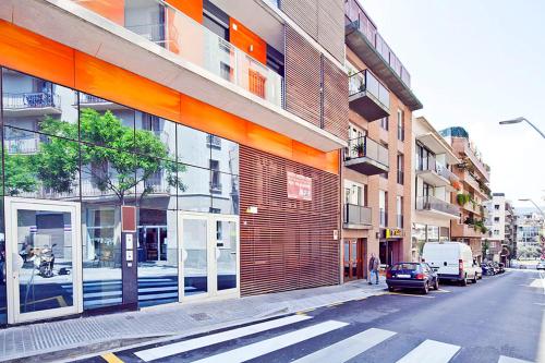 budynek na ulicy miejskiej z samochodem przed nim w obiekcie Barcino Inversions - Spacious Apartments near the City Center w Barcelonie