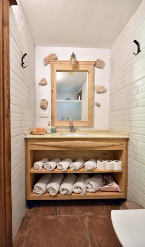 a bathroom with a sink and a mirror and towels at Pyramid Boutique Hotel in Kayakoy