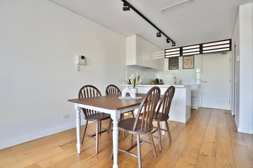 cocina y comedor con mesa y sillas en Lumière Urban Hideaway-Split Level ·Views ·Parking en Sídney